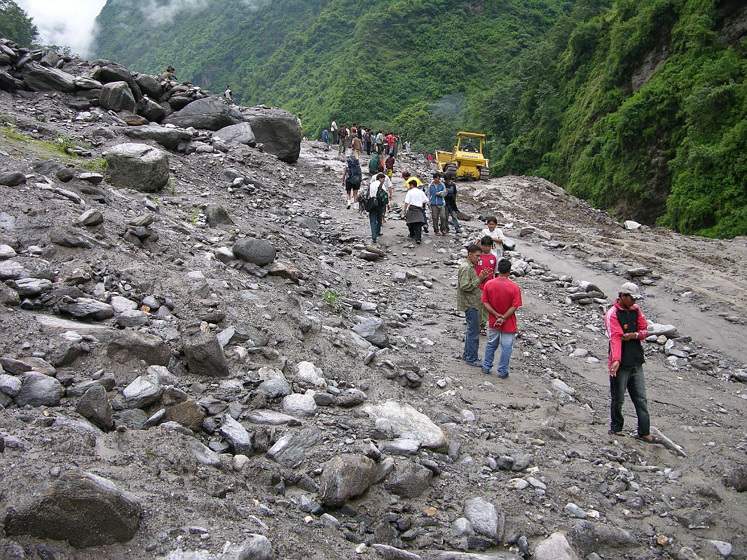 03 Landslide On Arniko Highway Just Before Kodari About 8km before the Nepalese border town of Kodari in July 2006, the same landslide that stopped us in July 2005 stopped us again. This time, the local porters were very organized, and after about an hour we were on our way again for the final few kilometres, Me-thinks this landslide is good for the local economy.